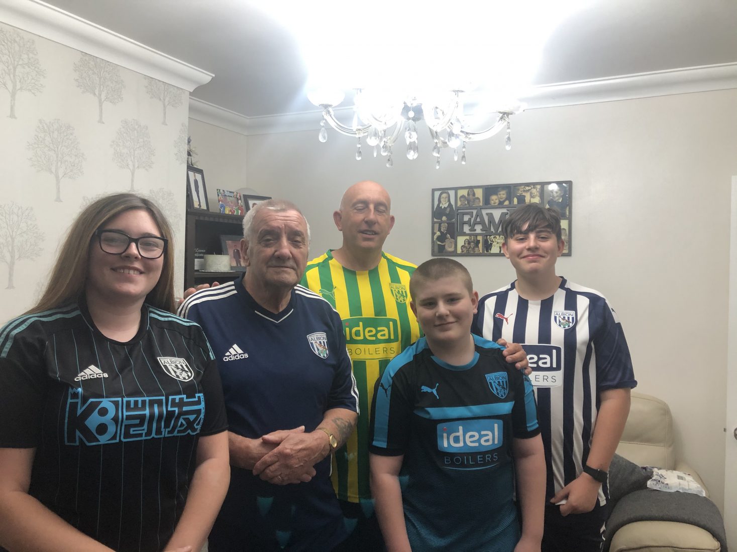 family photograph with two older men and three children who are all wearing West Bromwich Albion football shirts. 
